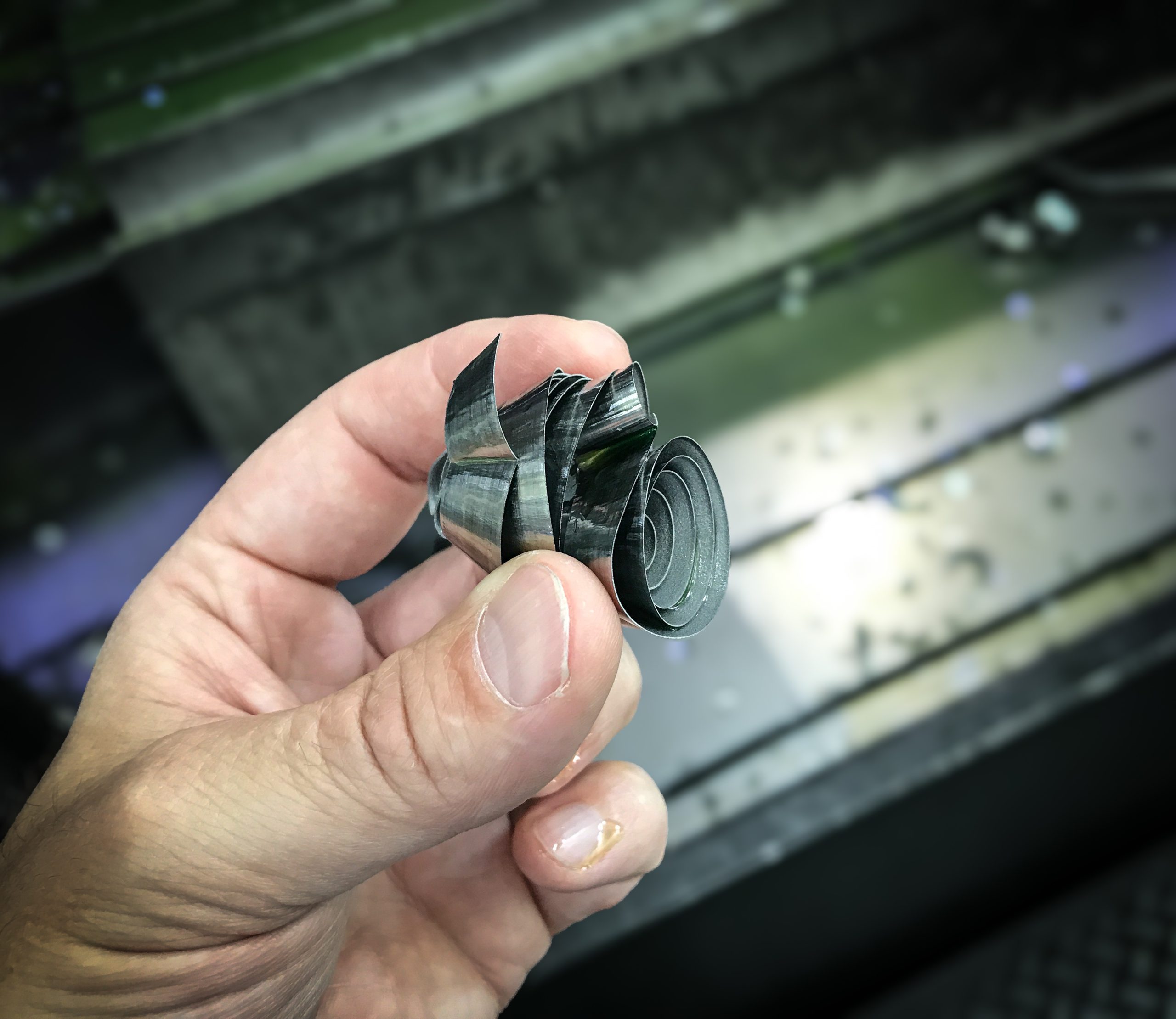 Hand zeigt Metallspäne auf Maschinentisch