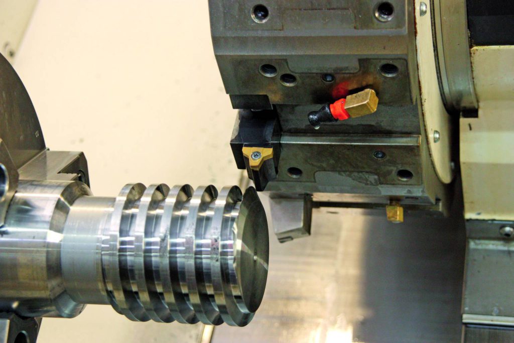 Drehmaschine schneidet Rillen in Metallzylinder